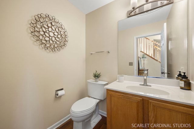 bathroom with baseboards, toilet, and vanity