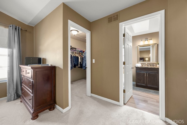 bedroom with visible vents, baseboards, a spacious closet, a closet, and light colored carpet