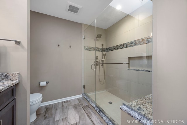 full bathroom with visible vents, wood finished floors, toilet, and a stall shower