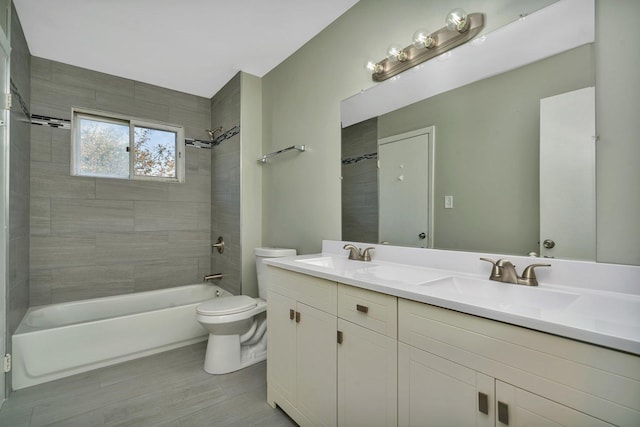 full bath featuring double vanity, bathtub / shower combination, a sink, and toilet