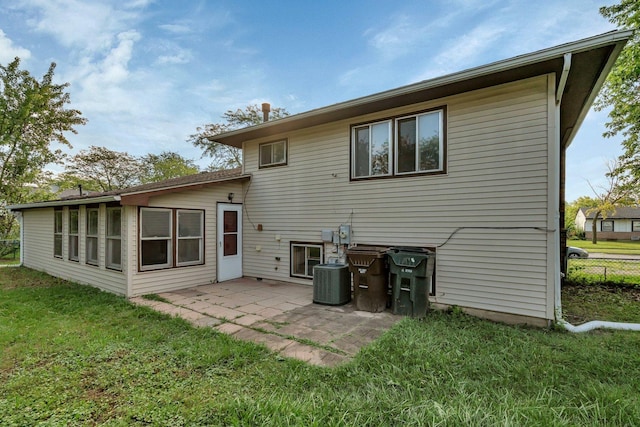 rear view of property featuring central air condition unit, a patio, and a lawn