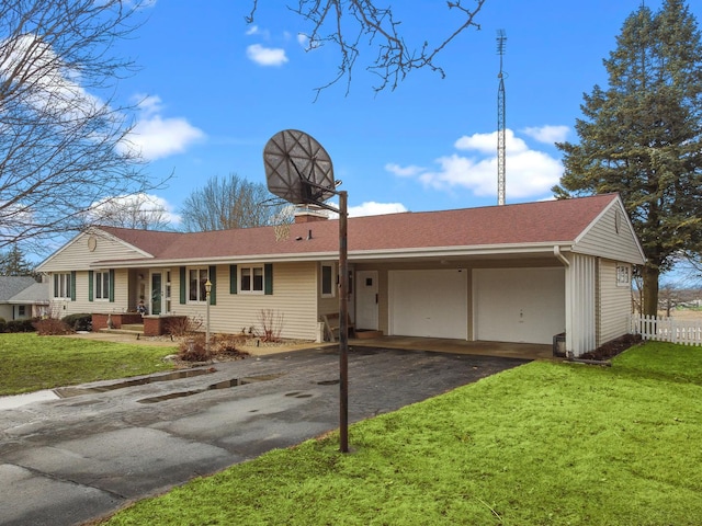 ranch-style house with a chimney, fence, aphalt driveway, and a front yard