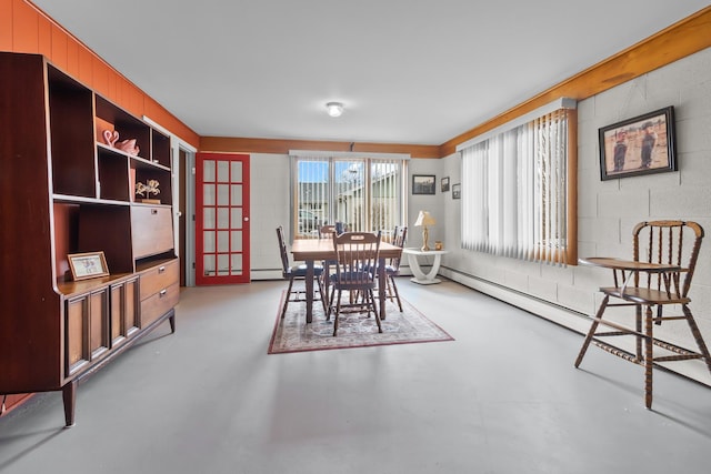 dining room with concrete flooring and concrete block wall