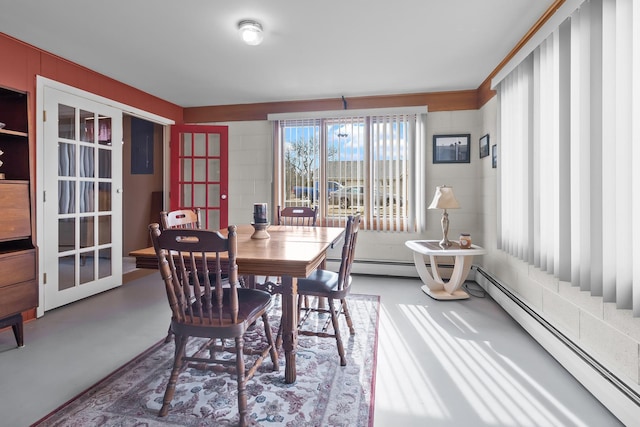 dining room featuring concrete floors and baseboard heating