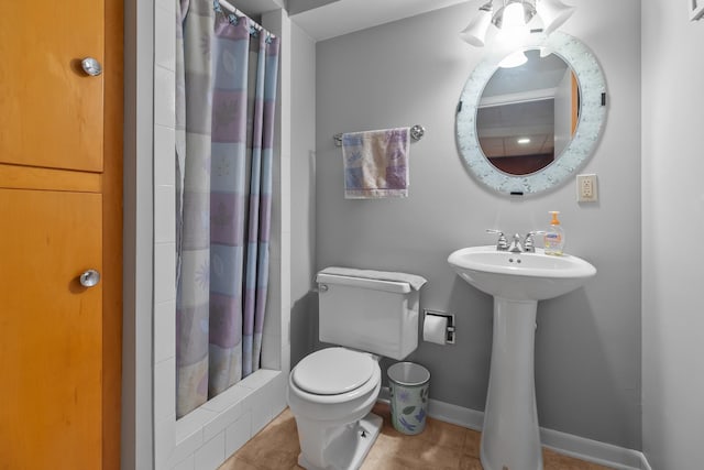 bathroom with a shower with curtain, baseboards, tile patterned flooring, and toilet