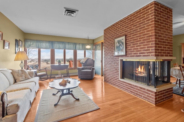 living room featuring wood-type flooring and a fireplace