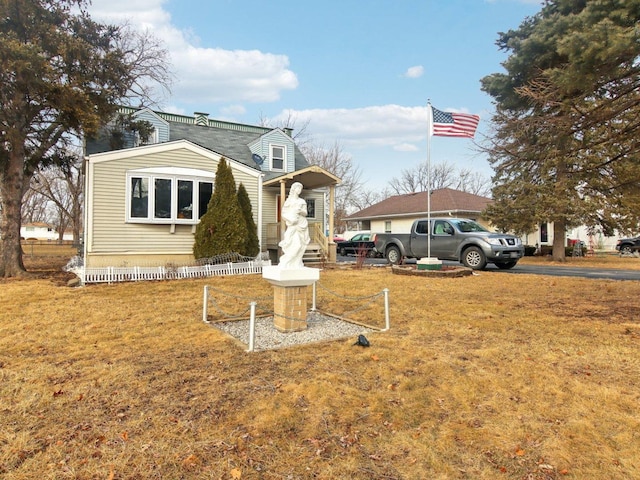 view of front facade with a front lawn and fence