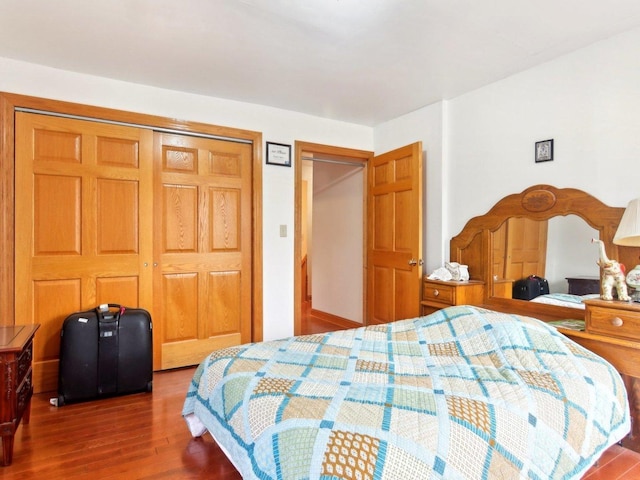 bedroom with dark wood-style floors and a closet