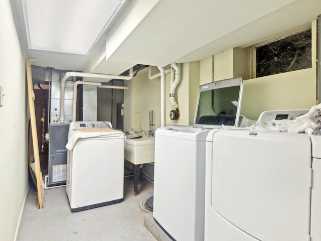 washroom featuring laundry area, washing machine and dryer, and a sink