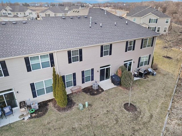 back of house with a patio area, a residential view, a lawn, and roof with shingles