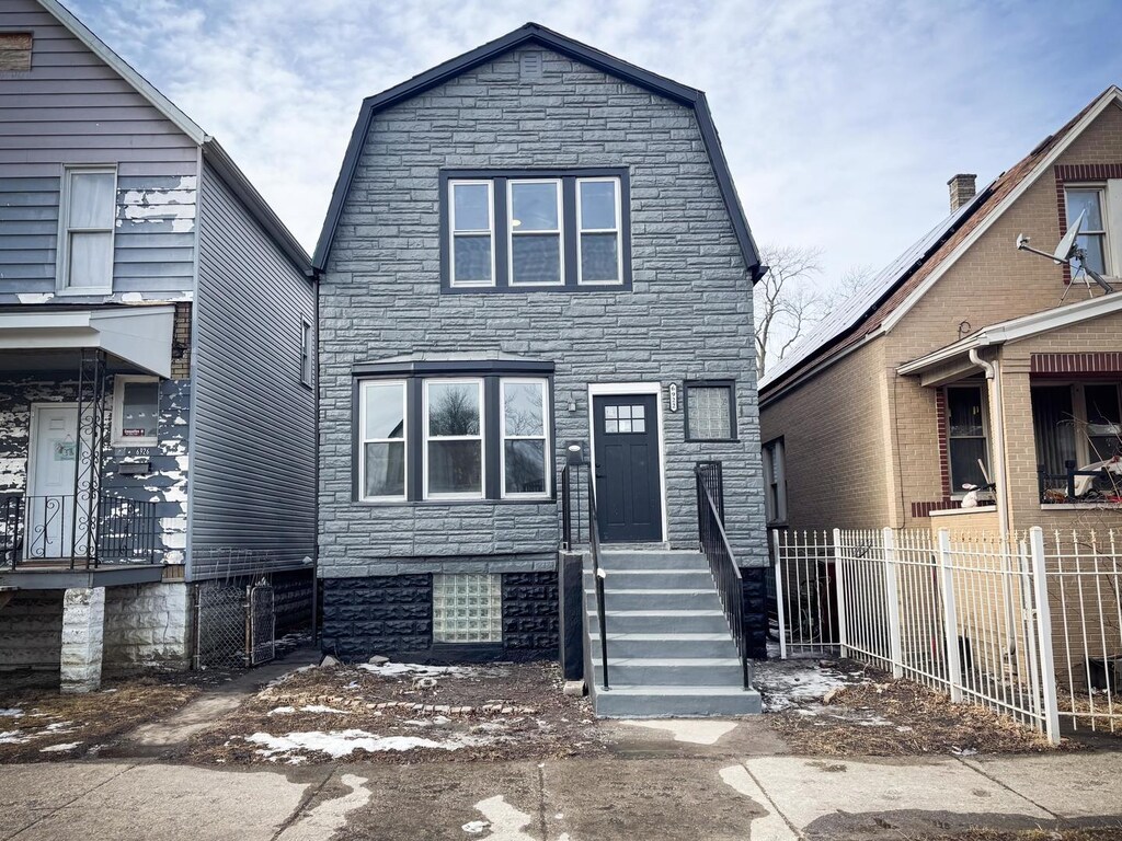 6922 S Winchester Ave, Chicago, IL 60636 - dutch colonial featuring stone siding, a fenced front yard, and a gambrel roof
