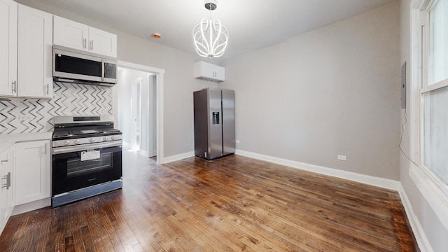 kitchen featuring pendant lighting, light countertops, appliances with stainless steel finishes, dark wood-type flooring, and white cabinetry