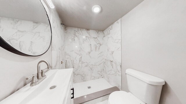 bathroom featuring a shower stall, vanity, and toilet