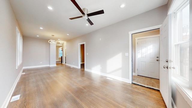 interior space with baseboards, light wood-type flooring, a ceiling fan, and recessed lighting