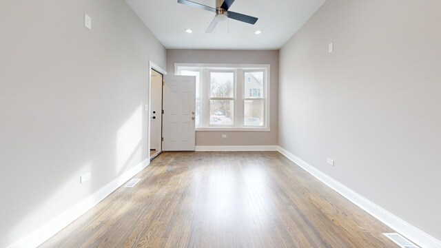 empty room with recessed lighting, wood finished floors, visible vents, a ceiling fan, and baseboards