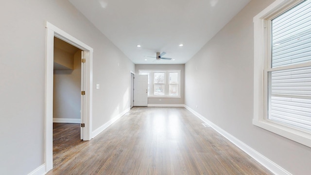 unfurnished room with ceiling fan, recessed lighting, wood finished floors, and baseboards