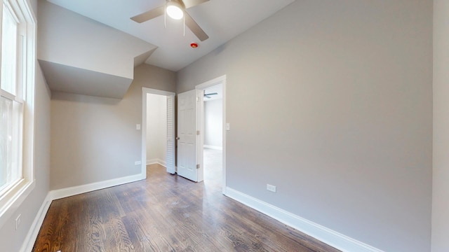 unfurnished bedroom with ceiling fan, vaulted ceiling, baseboards, and dark wood finished floors