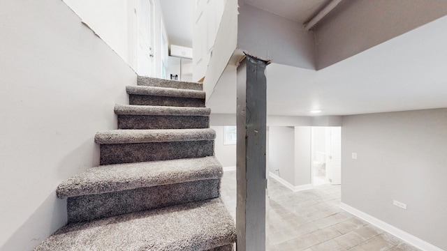 staircase featuring baseboards