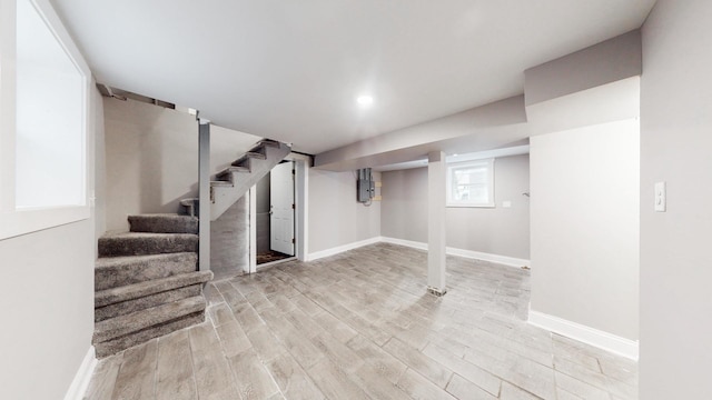 basement featuring stairs, light wood-type flooring, and baseboards