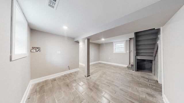 below grade area with recessed lighting, visible vents, light wood-style flooring, and baseboards