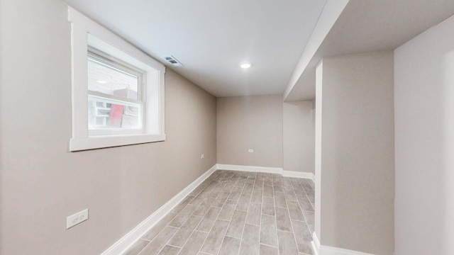 unfurnished room with light wood-type flooring, visible vents, and baseboards