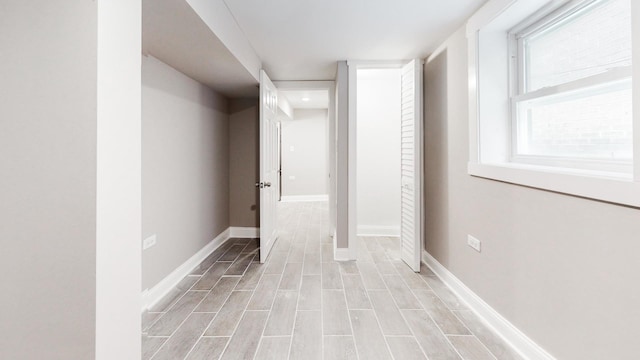 hallway featuring light wood-style floors and baseboards