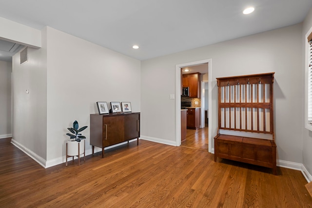 hallway with attic access, baseboards, visible vents, dark wood-style floors, and recessed lighting