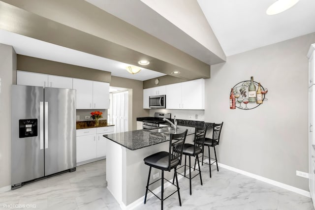 kitchen featuring a peninsula, marble finish floor, white cabinetry, and stainless steel appliances