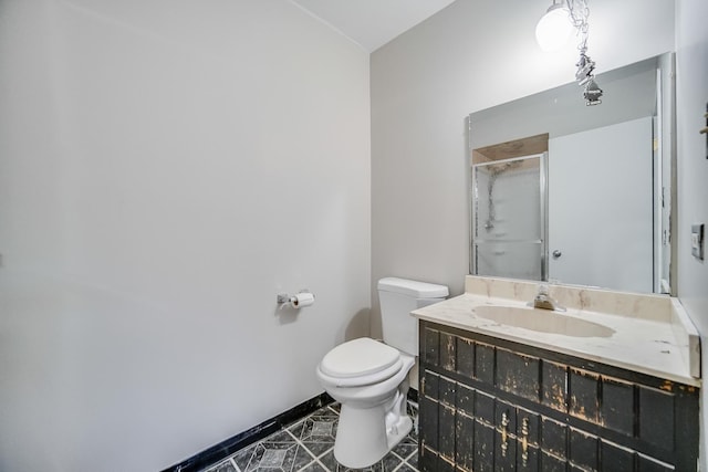 bathroom with a shower with shower door, vanity, toilet, and baseboards