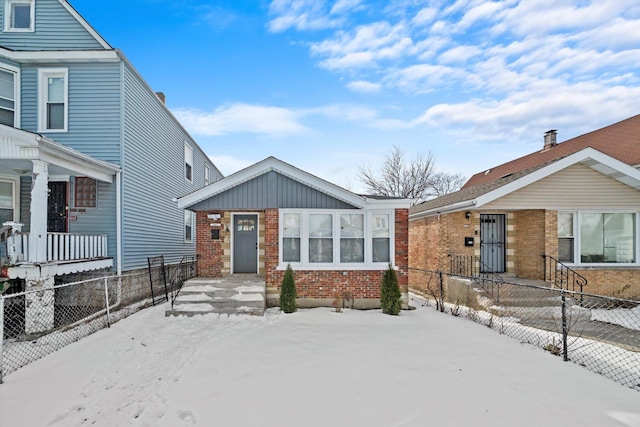 view of front of home featuring brick siding, board and batten siding, and fence private yard