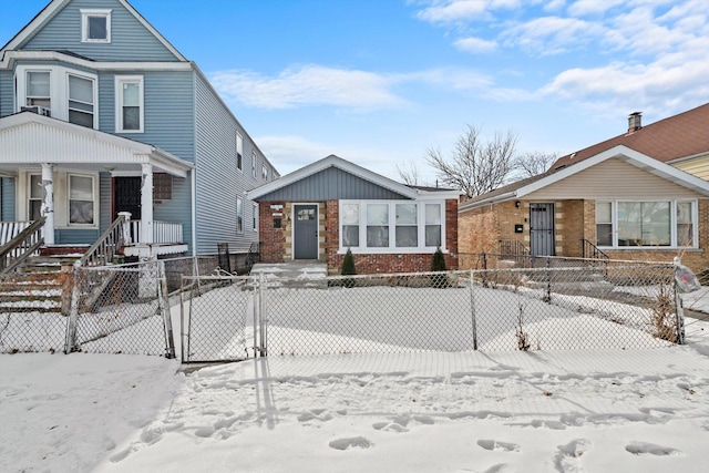 view of front of property with brick siding, a fenced front yard, and a gate