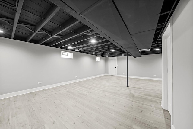 finished below grade area featuring light wood-style flooring and baseboards