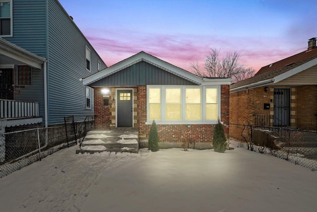 exterior space with brick siding, board and batten siding, and fence