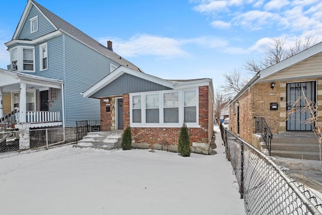 view of front facade featuring brick siding and a fenced front yard