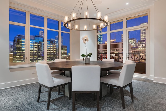 dining room featuring a chandelier, a view of city, crown molding, and baseboards