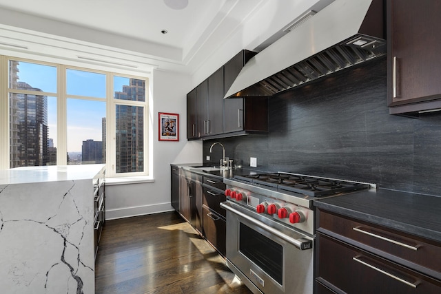 kitchen with a city view, a sink, premium stove, dark countertops, and custom range hood