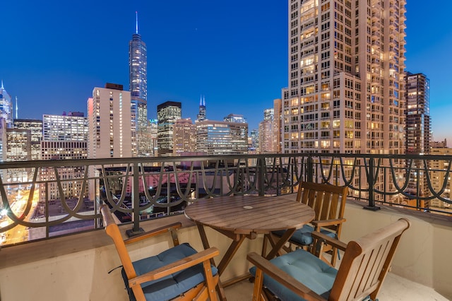 balcony at dusk featuring a city view