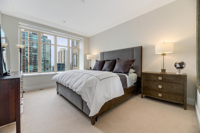 bedroom with light carpet, crown molding, baseboards, and a city view