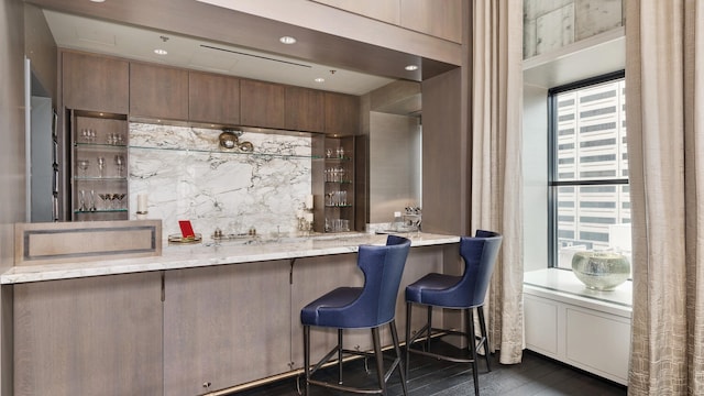 bar with plenty of natural light, tasteful backsplash, and indoor wet bar