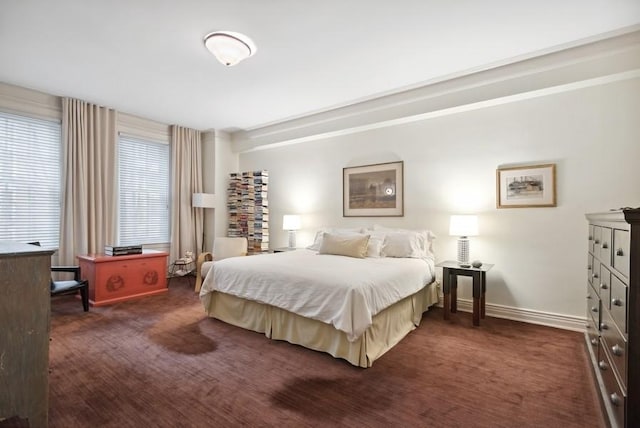 bedroom featuring dark colored carpet and baseboards