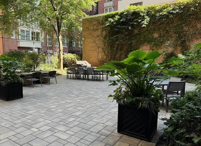 view of home's community with outdoor dining space and a patio area