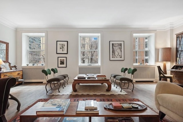 sitting room with ornamental molding and wood finished floors