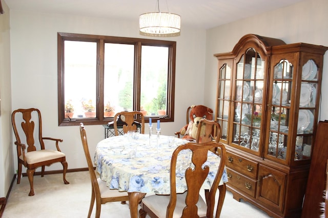 dining space with light carpet and baseboards