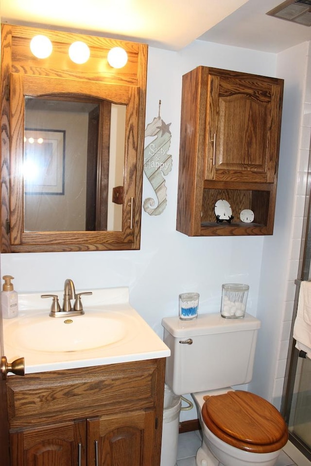 bathroom with toilet, visible vents, and vanity