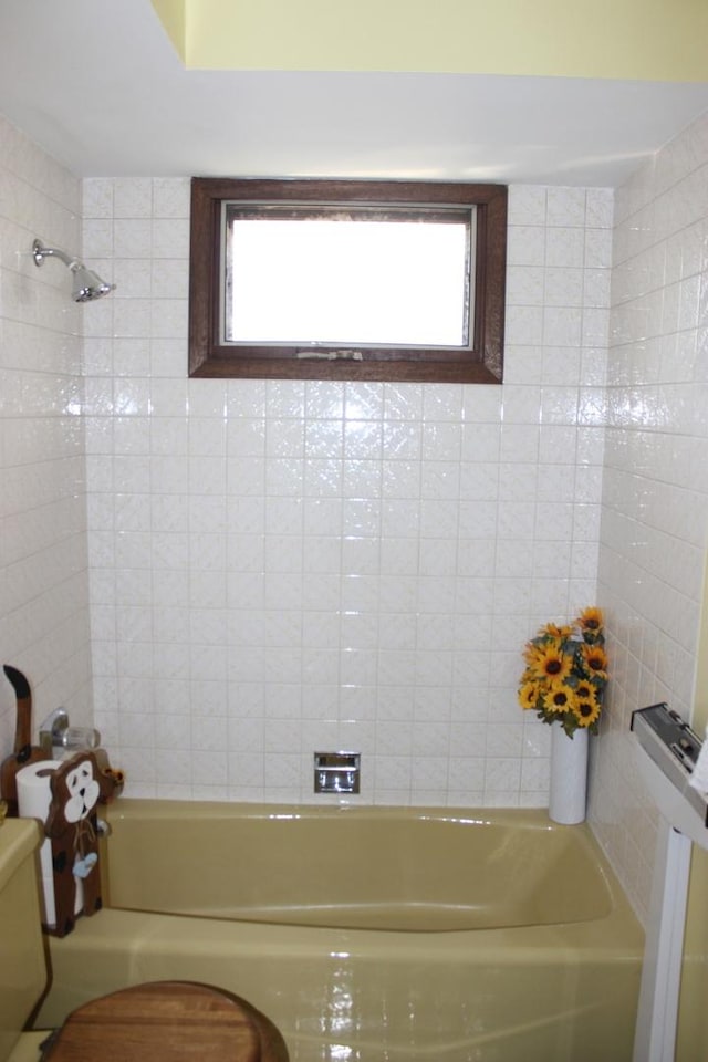 bathroom with washtub / shower combination and toilet