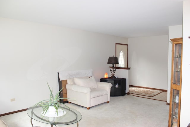 living area with light carpet and baseboards