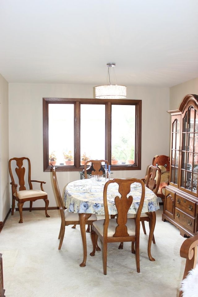 dining room with light colored carpet and baseboards