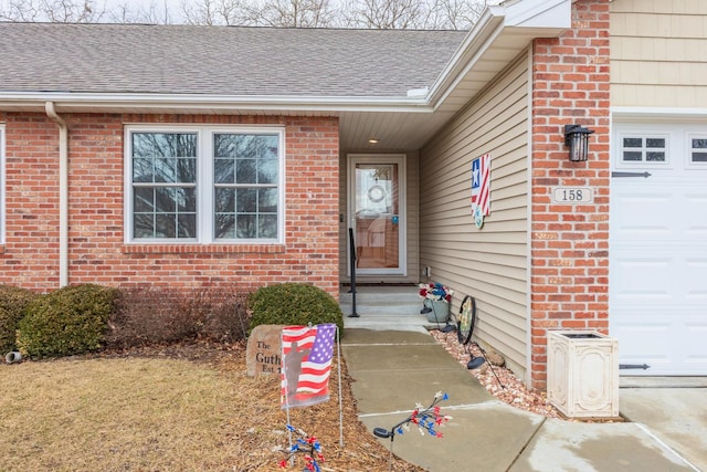 property entrance with an attached garage, brick siding, and roof with shingles