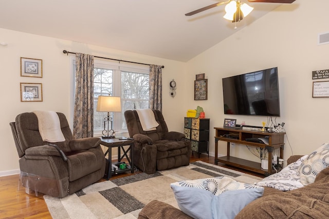 living area featuring light wood finished floors, visible vents, a ceiling fan, vaulted ceiling, and baseboards