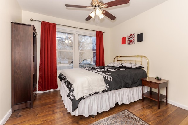 bedroom featuring dark wood finished floors, a ceiling fan, and baseboards